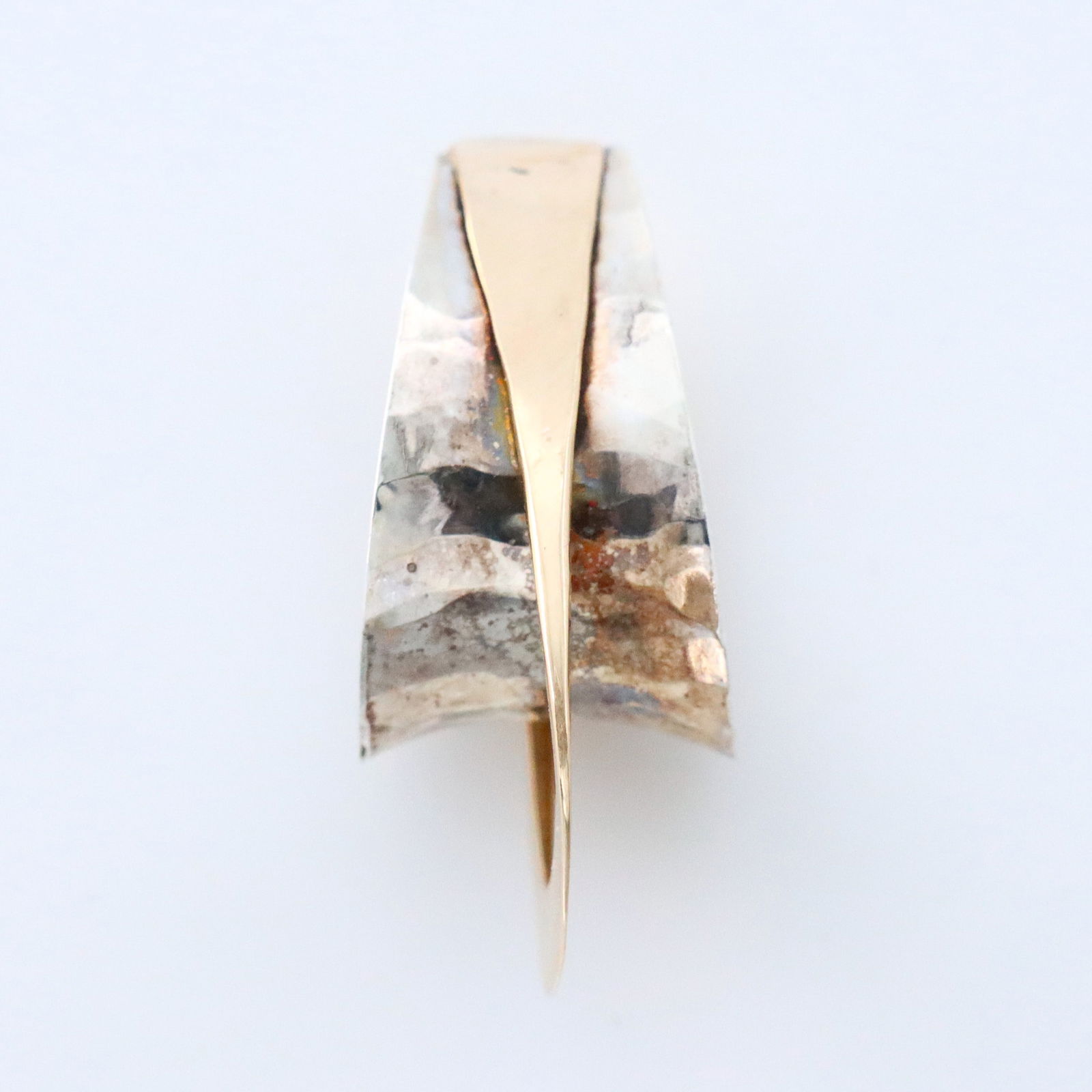 14k Gold & Sterling Necklace Enhancer: A vintage 14k Gold and Sterling Silver necklace enhancer. Teardrop form with two arches of Gold and hammered Sterling. Marked "SS 14k PJ". 3.0 grams total. Some surface wear. 1 1/8" high. ESTIMATE $10