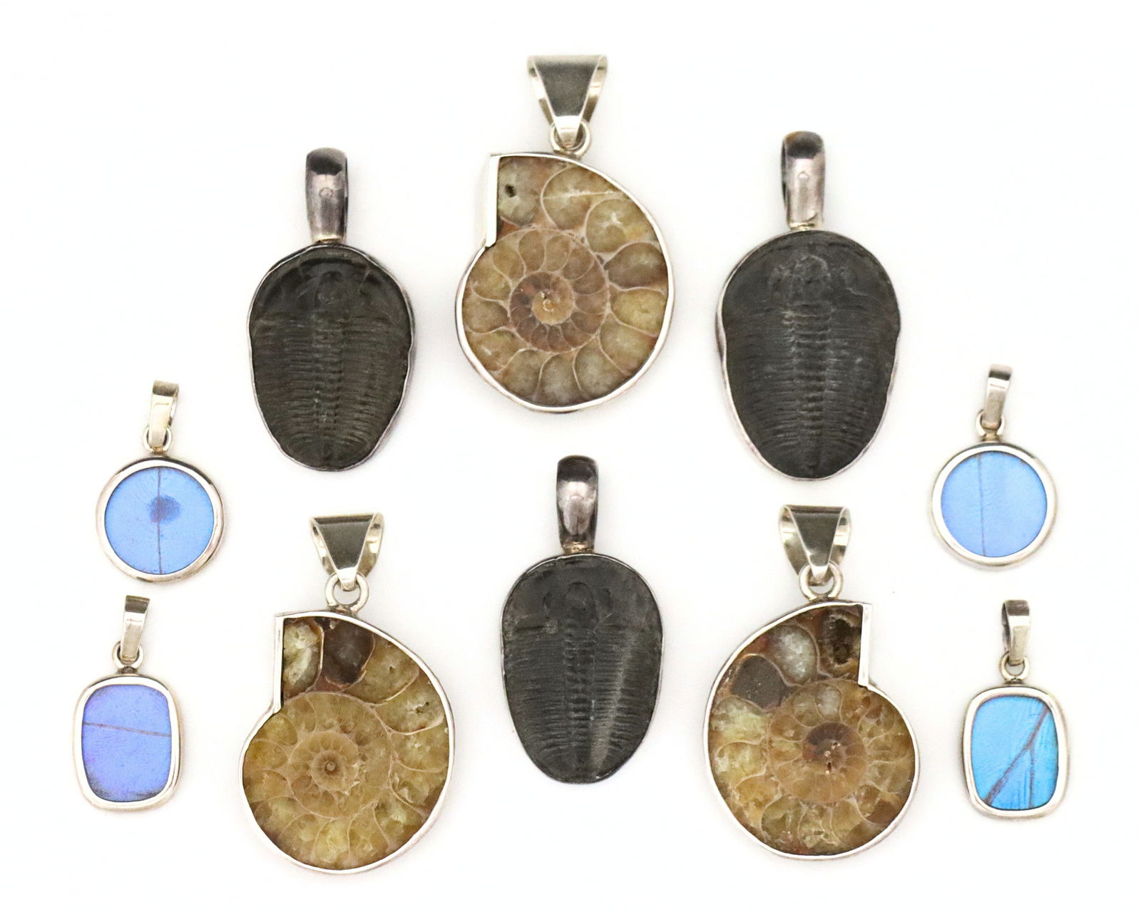 10 Sterling Pendants w. Natural Elements: Ten vintage Sterling Silver necklace pendant with natural elements. Includes three with bezel set Ammonite fossils, three with bezel set Trilobite fossils, and four medallions with Peruvian Butterfly