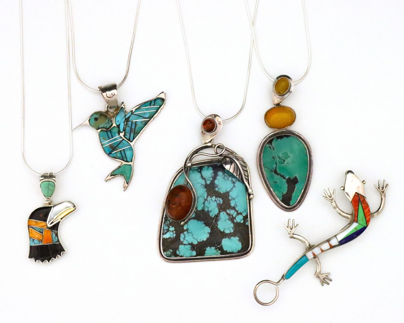 5 pc Native American Sterling & Turquoise Jewelry: Five pieces of vintage Native American Sterling Silver and Turquoise jewelry. Includes two geometric pendant necklaces with Amber cabochons, two inlaid Bird form pendant necklaces with small Jet and C