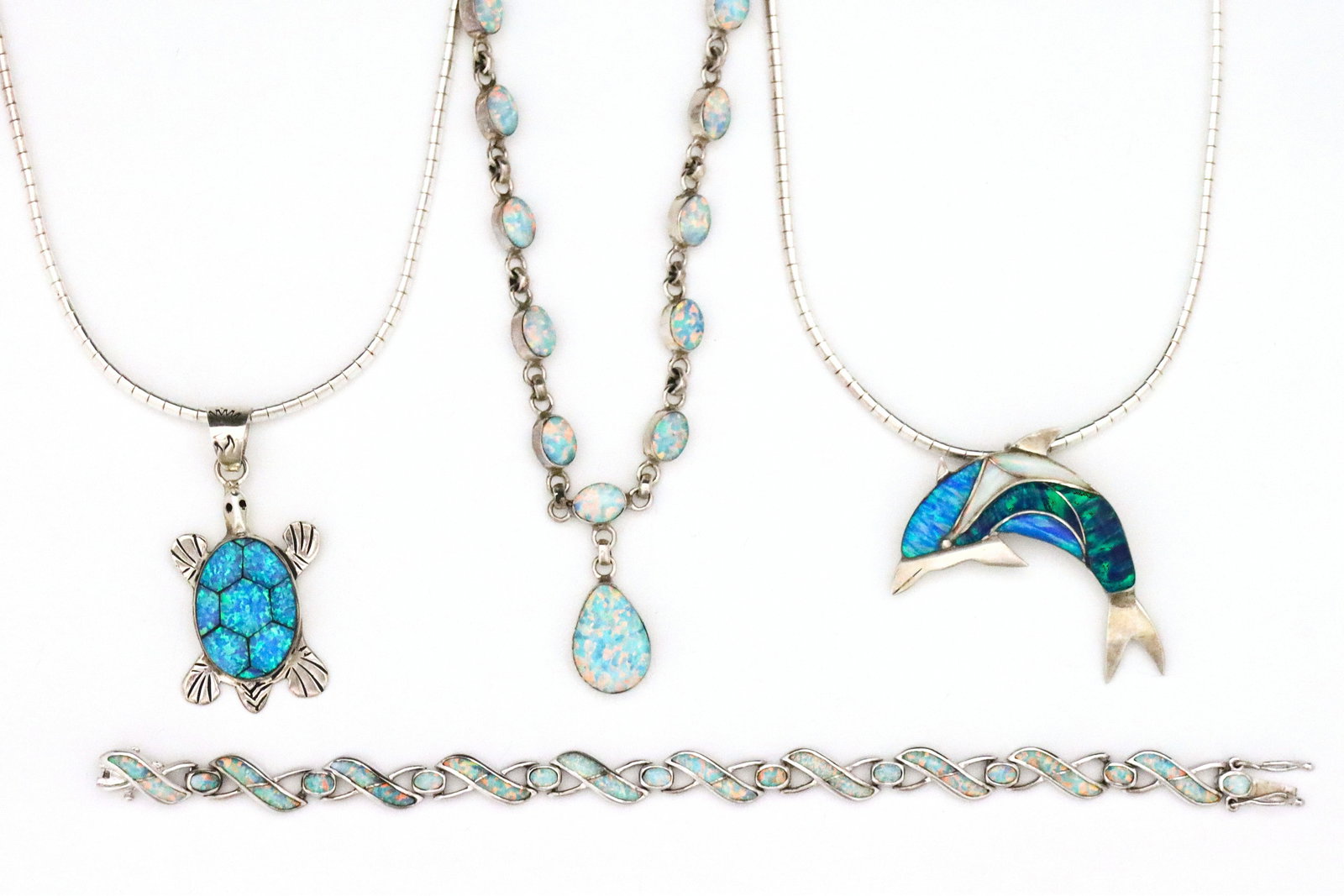 4 pc Native American Sterling & Opal Jewelry: Four pieces of vintage Native American Sterling Silver and Opal jewelry. Various forms with Blue and White Opal, includes a Turtle form pendant necklace, a Dolphin form pendant necklace that converts