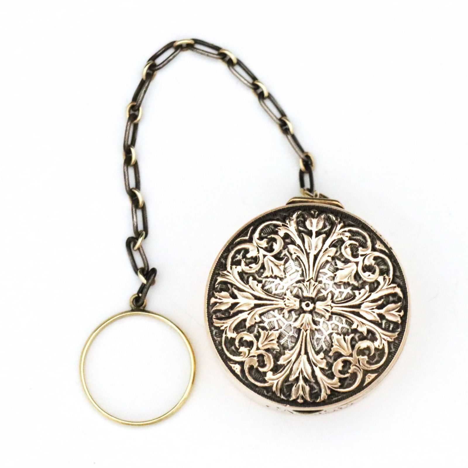 R. Blackinton & Co. 14k Gold & Sterling Compact: An early 20th century R. Blackinton & Co. 14k Gold and Sterling Silver compact. Hinged circular Sterling box with engraved foliate design and 14k Rose Gold finish, with a chain and 14k Yellow Gold fin