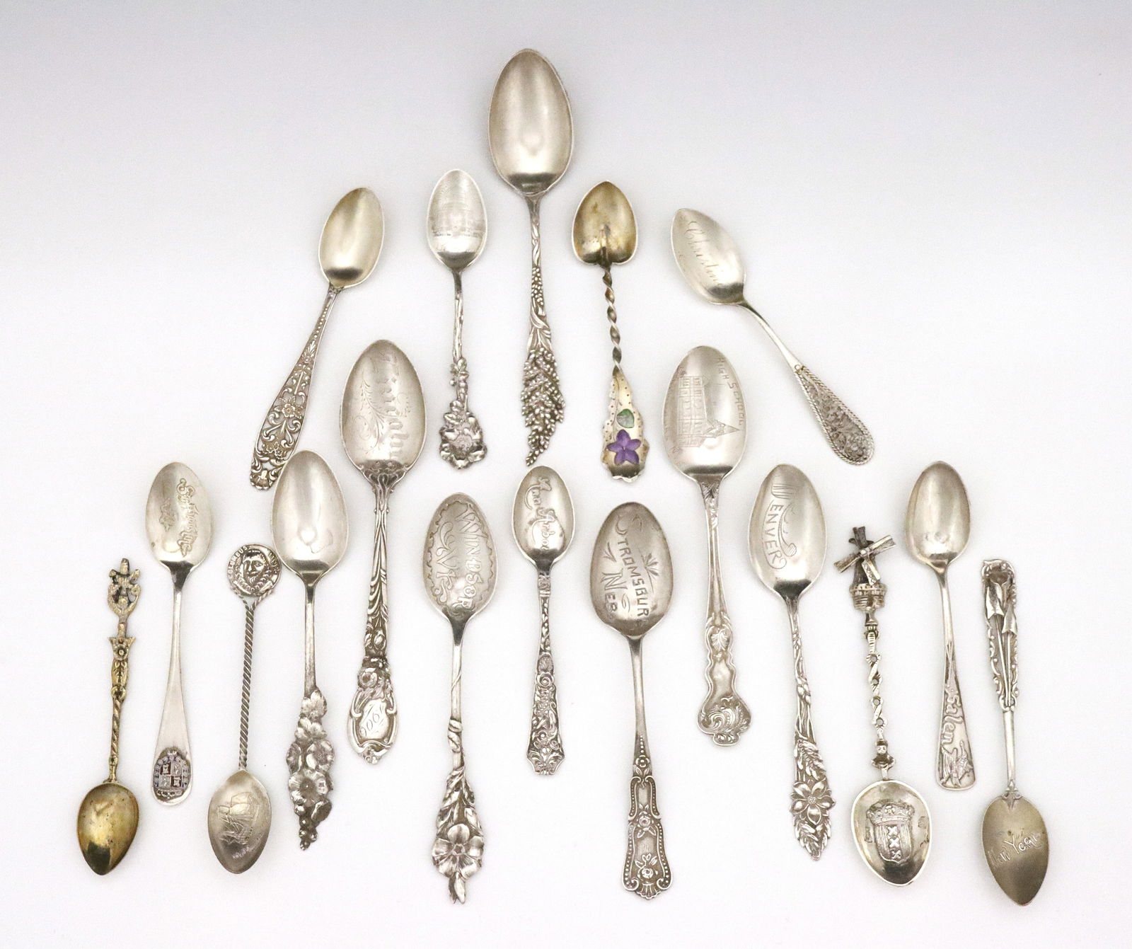 17 Sterling Silver: A collection of seventeen Sterling Silver souvenir spoons and a display rack. Includes seventeen American and Dutch Sterling Silver spoons and one Italian silverplate spoon, displayed on a shaped