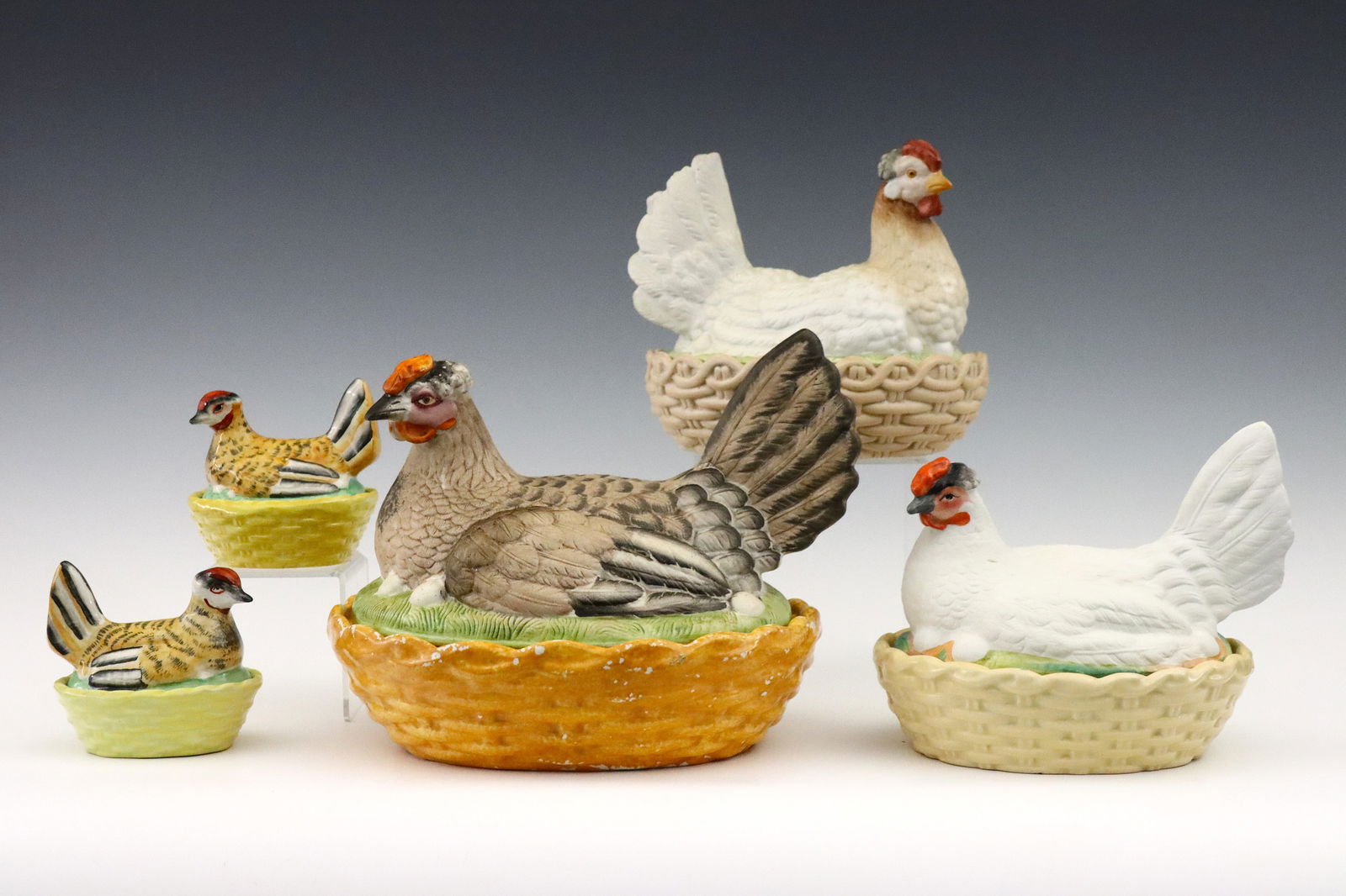 5 Staffordshire Hen on Nest Boxes: Five late 19th century Staffordshire Hen on Nest covered boxes. Molded form of a nesting hen over basket form boxes with polychrome decoration. One small box stamped "Staffordshire Stoneware / England
