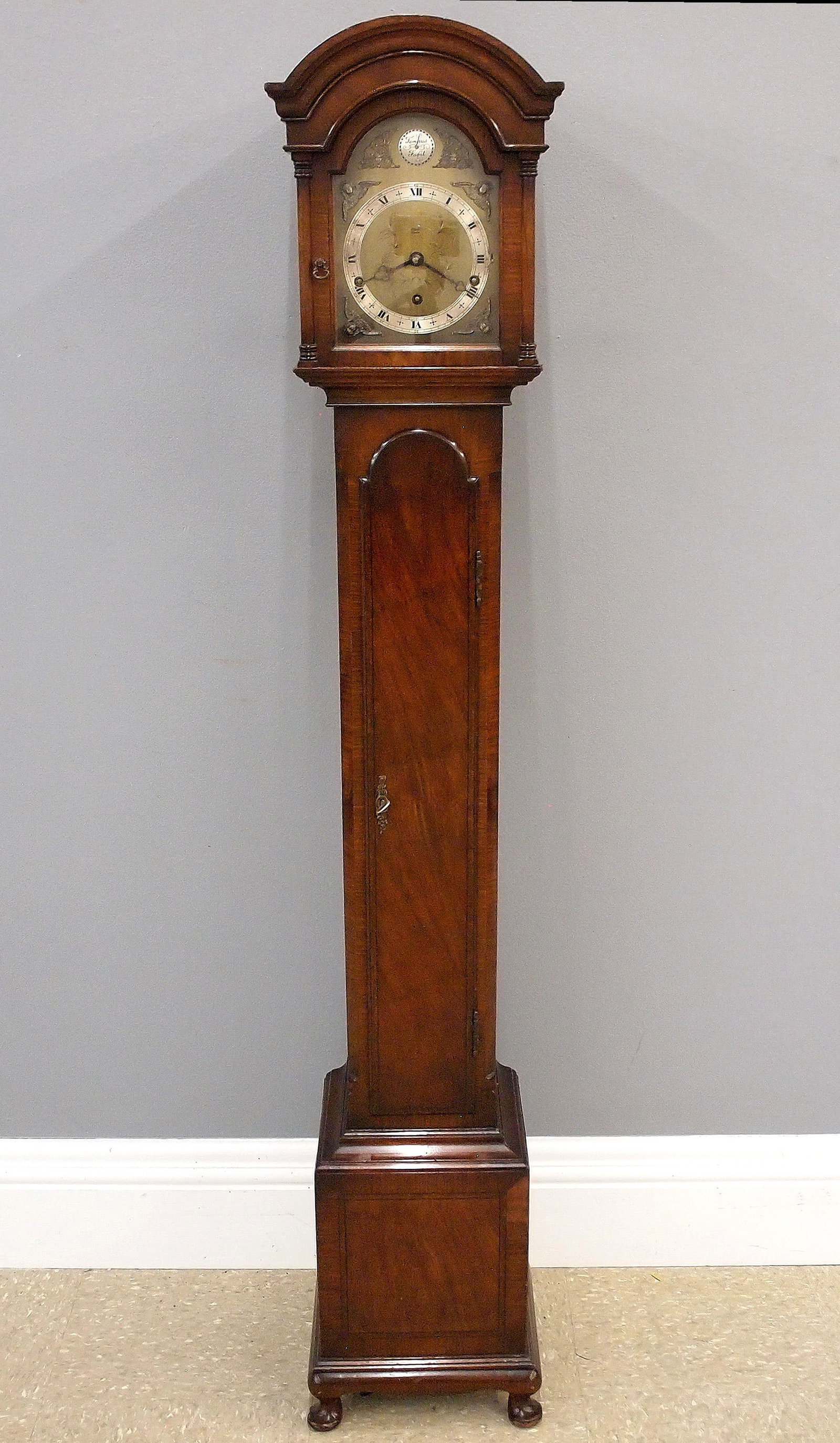 Elliott Grandmother Clock: A 1960's English Grandmother clock by Elliott of London. 8-day spring driven movement with quarter hour chimes, engraved Brass dial with cast spandrels and Silvered chapter ring with Roman numerals,