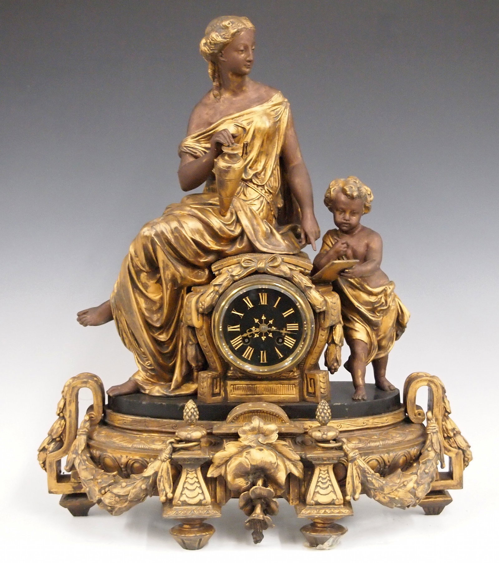 3 Pc French Clock Set: A late 19th century French 3 pc clock set. 8-day time and strike movement with Black slate dial and incised Gold Roman numerals. Louis XVI style spelter figural case with a woman and child on a
