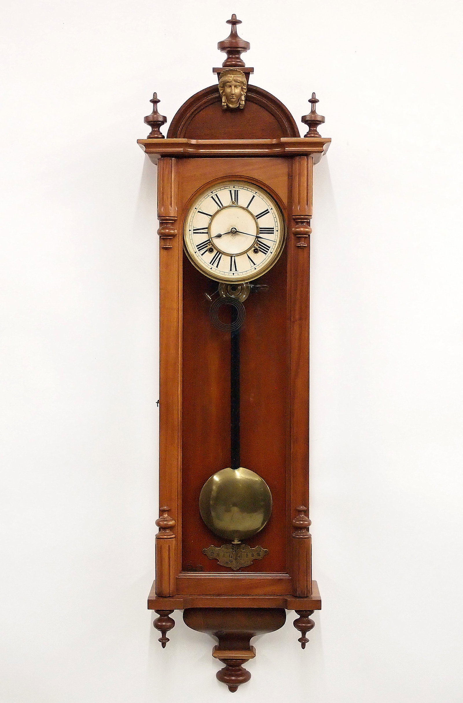 Ansonia Capitol Model Wall Clock: A 20th century Ansonia Capitol model wall clock. 8-day spring driven time and strike movement with papered metal dial and Roman numerals. Later craftsman made Walnut case with arched crown and cast