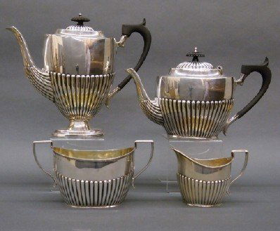 Sterling Silver teaset: An early 20th century English Sterling Silver Tea and Coffee set, by Barker Brothers, Birmingham. Four pieces with Regency style fluted bodies, Gold washed interiors, some with Ebonized knobs and hand