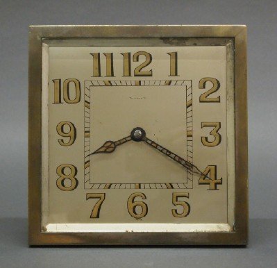 Tiffany & Co desk clock: An early 20th century Tiffany & Co. desk clock. Silver plated frame with hinged support and a silvered dial with enameled detail. Case wear, some damage to the enameling on hands. 7 3/4" high. ESTIMAT