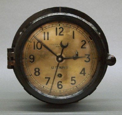 Chelsea Ships clock: A mid 20th century Chelsea "U. S. Navy" model ships clock. 8-day time only movement with a Brass dial marked "Chelsea Clock Co. Boston" with Arabic numerals in a Black Bakelite case with hinged door. 