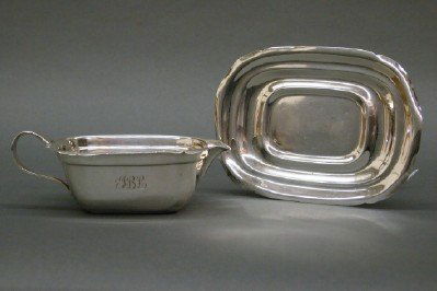 Sterling gravy boat: A Sterling Silver gravy boat and underplate by Reed & Barton. Simple shaped edges. Minor wear, monogrammed. 7 1/2" long. 9.65 troy oz. total. ESTIMATE $200-300