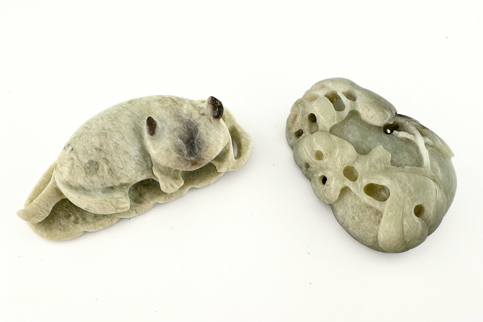 2 Chinese Carved Jade Figures: Two Chinese carved Jade figures. Includes auspicious carvings of a cat curled on a leaf and a double gourd with characters on the reverse. Surface wear and minor inclusions, some discoloration, peach 