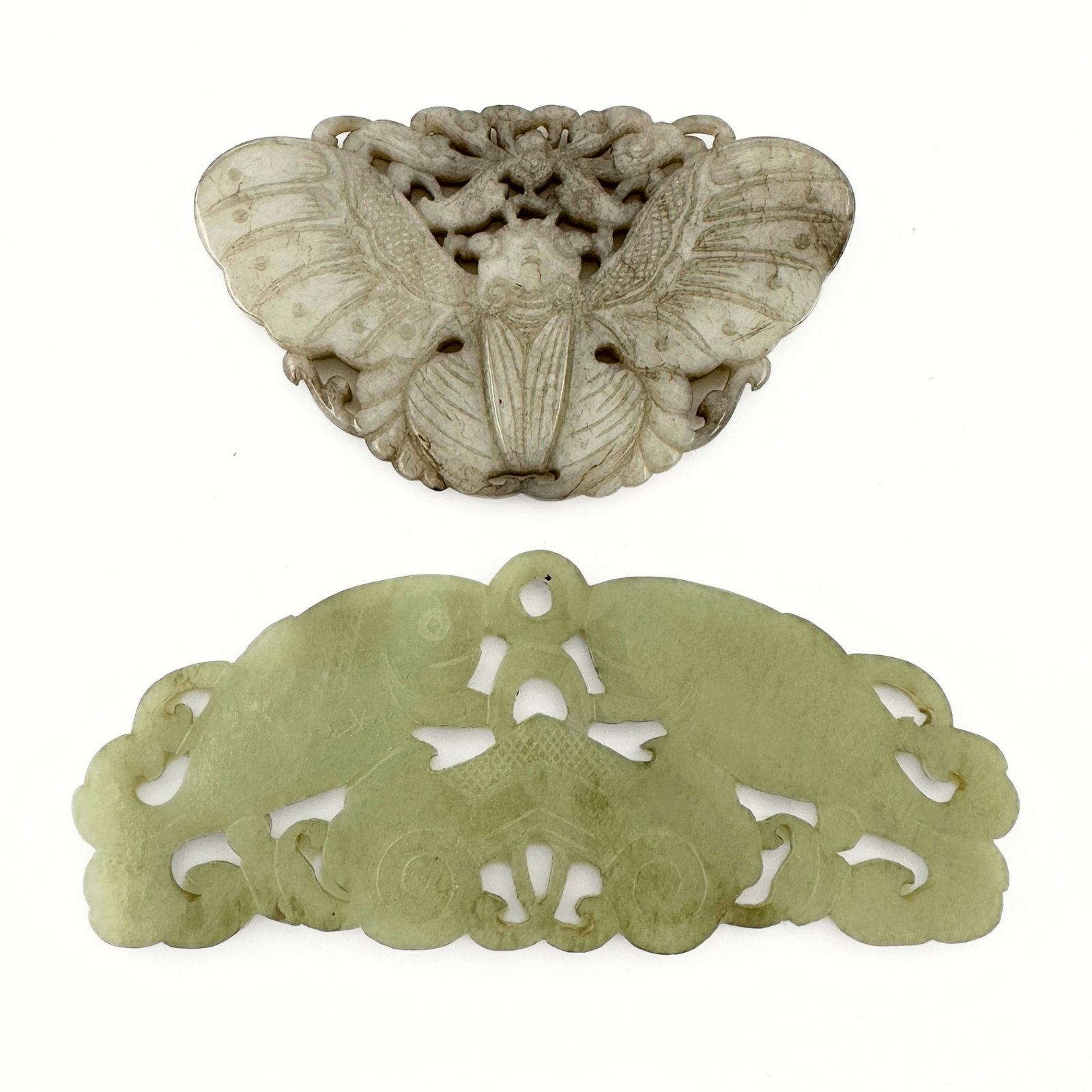 2 Chinese Carved Jade Plaques: Two Chinese carved Jade plaques. Reticulated and relief carved designs depicting a moth and an arched chime stone in the form of a pair of fish. Some surface wear and minor inclusions, areas of discol
