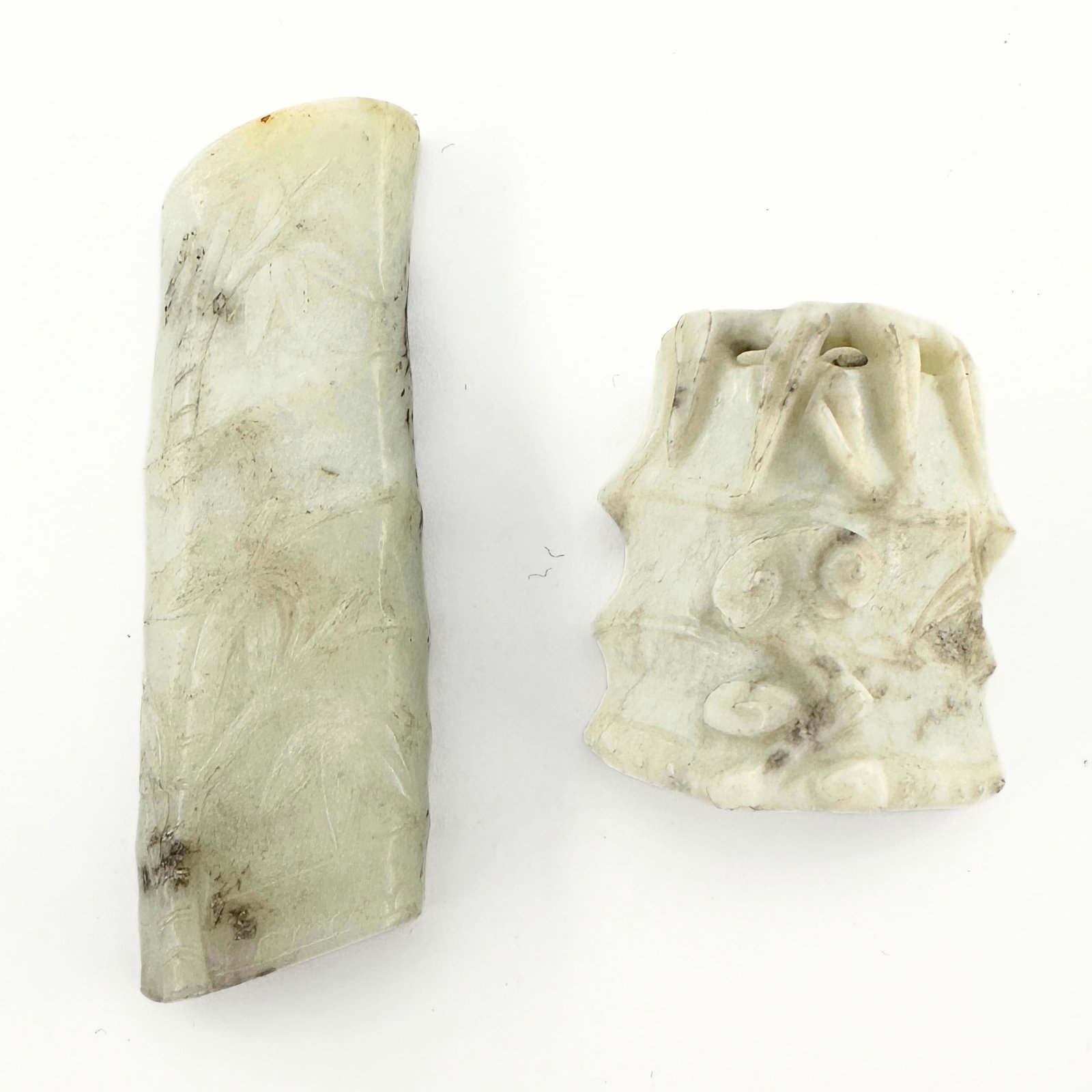 2 Chinese Carved Jade Figures: Two Chinese carved Jade figures. Includes auspicious carvings of bamboo segments. Longer piece drilled for pendant at top. Minor surface wear and inclusions, some discoloration. Up to 3" high. ESTIMAT