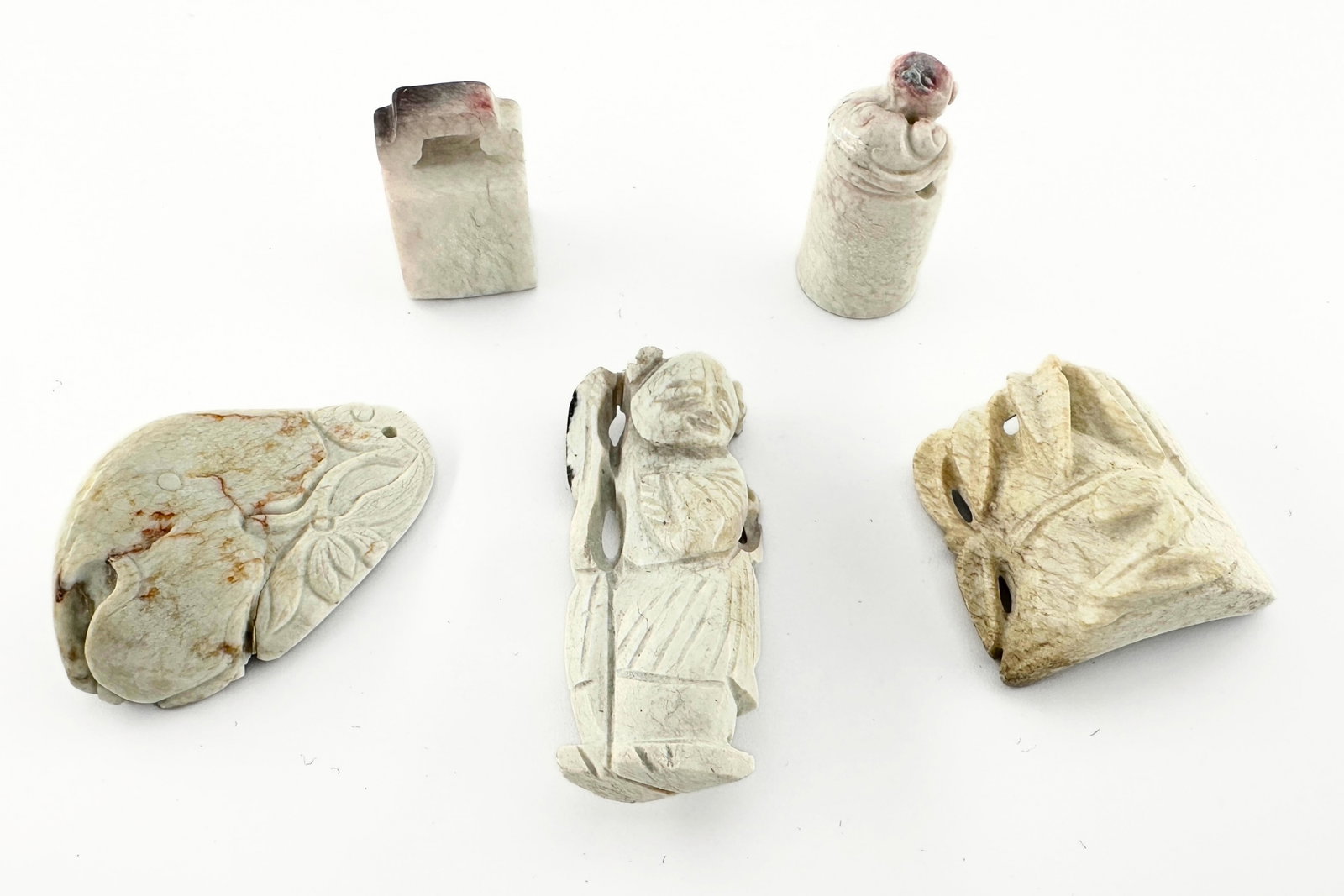 5 Chinese Carved Jade Figures & Seals: Five Chinese carved Jade figures and seals. Includes auspicious carvings of a Sage, peach and bamboo segment, with two carved y nzhang seal stones. Some surface wear and discoloration, a few minor inc