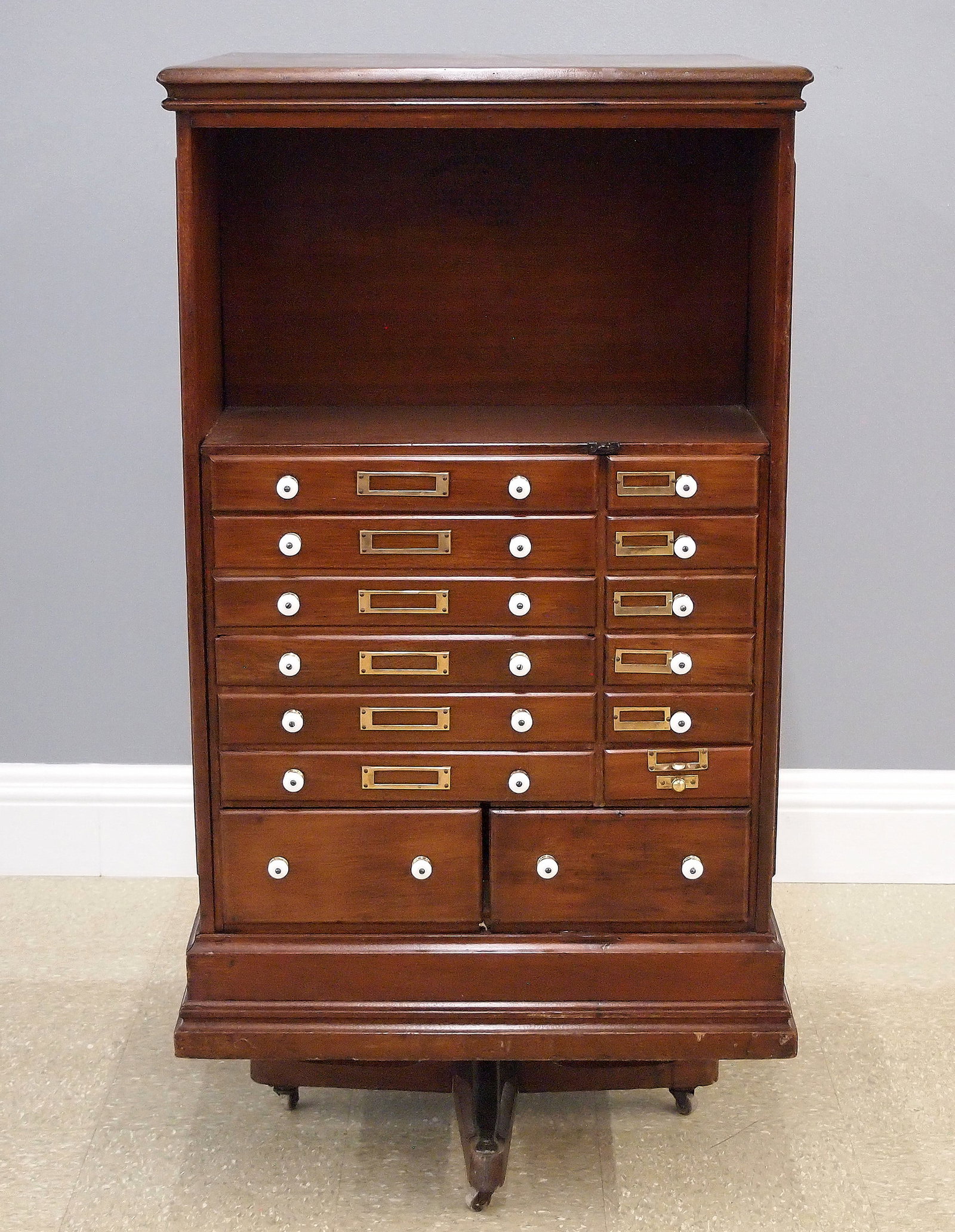 Danner's Revolving Lawyer's Cabinet: A late 19th century Danner's Patent Revolving Lawyer's Cabinet. Walnut construction features small drawers with porcelain knobs and paneled doors enclosing small shelves on blocked plinth with revolvi