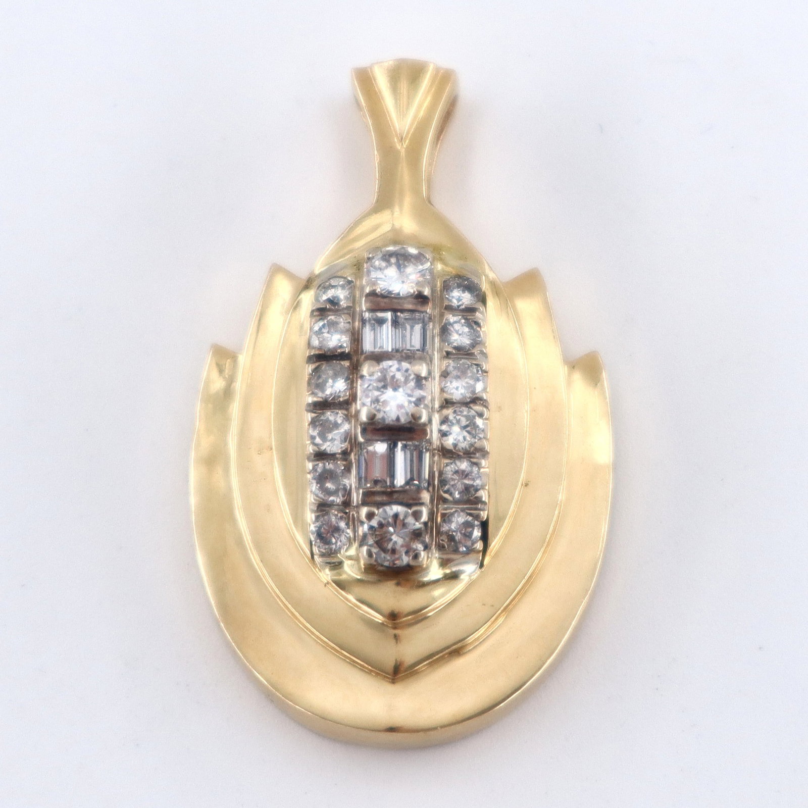 14k Gold & Diamond Necklace Pendant: A 14k Gold and Diamond necklace pendant. Features three central round cut prong set Diamonds, approx. 3.5 to 3.8 mm each, flanking four channel set Diamonds baguettes, between twelve additional round 