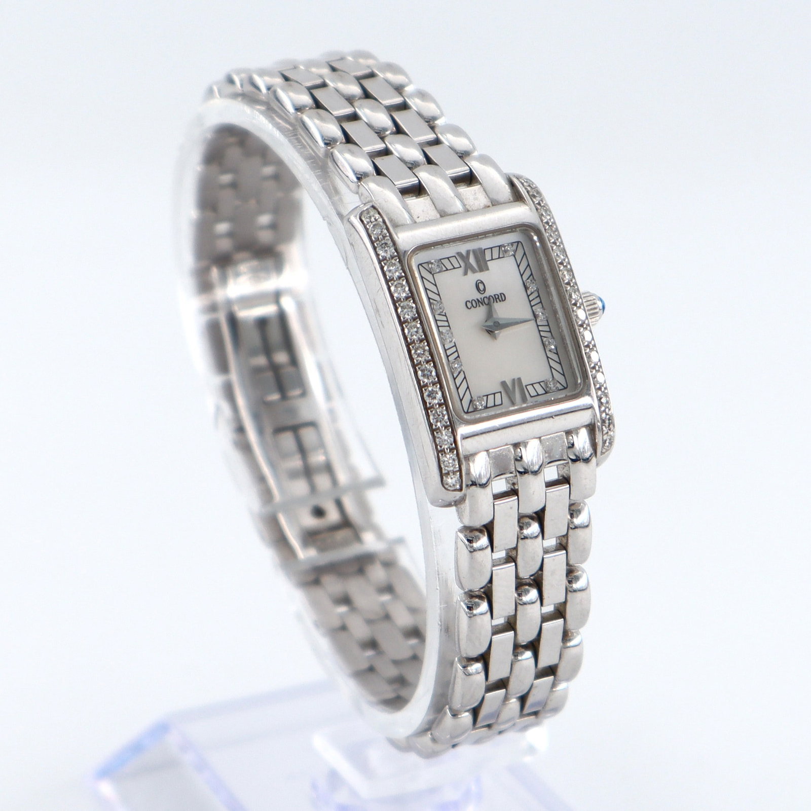 Concord 18k Gold Ladies Watch: A ladies Concord "Veneto" 18k White Gold wristwatch. 27 mm 18k Gold case with Quartz movement, Mother of Pearl dial and Roman numerals with Diamond chip markers, serial #1116709. Twenty-eight round cu
