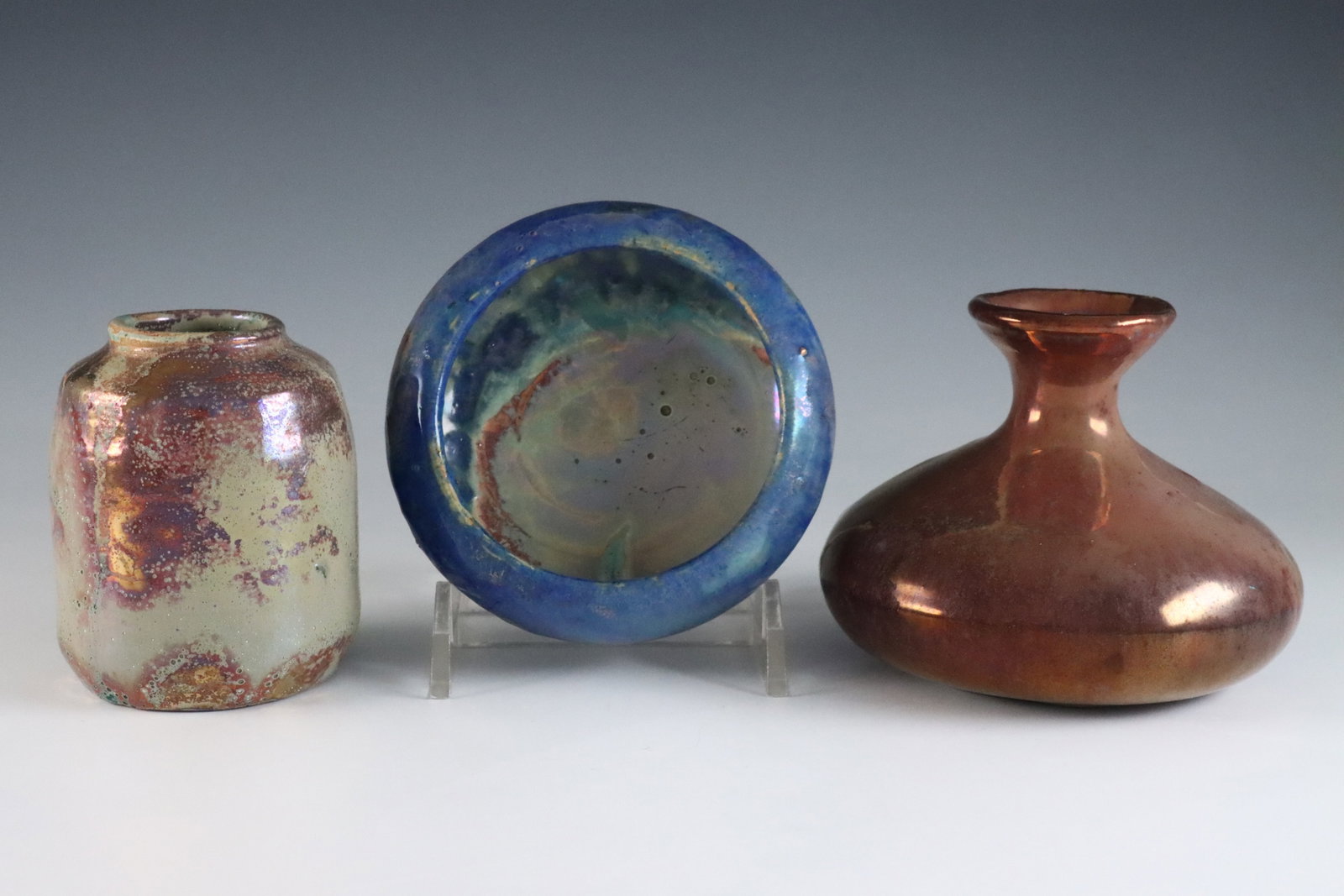 3 Miniature Pewabic Pottery Vessels: Three early 20th century miniature Pewabic Pottery vessels. Each with iridescent glazes, includes a cylindrical vase in Pale Green, Purple and Gold, a bottle form vase in Oxblood, Pale Green and Gold,