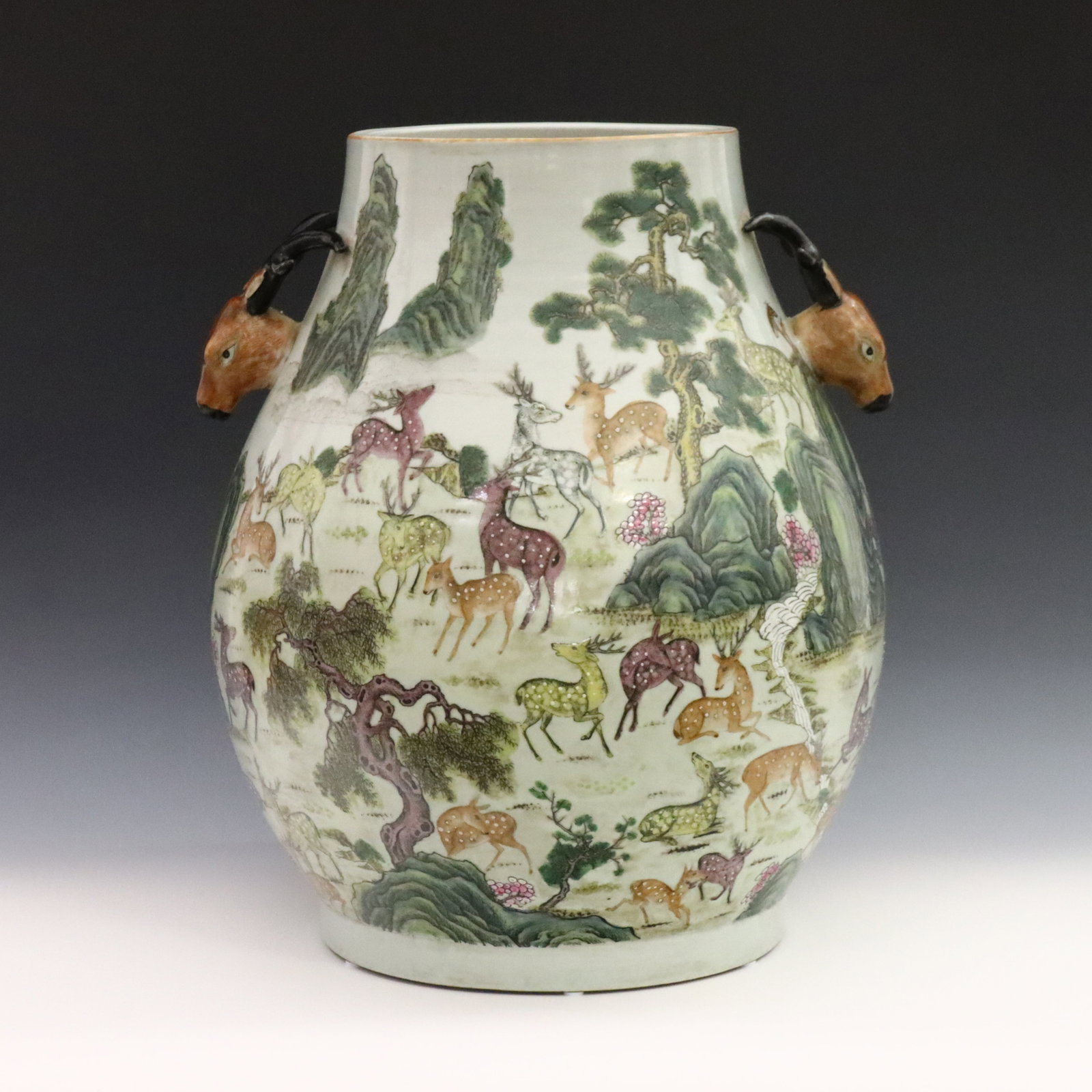 Chinese Hundred Deer Vase: A Chinese porcelain "Hundred Deer" vase. Baluster form vase with two molded Stag form handles at either side, having a white ground and polychrome enamel decoration depicting a multitude of deer withi