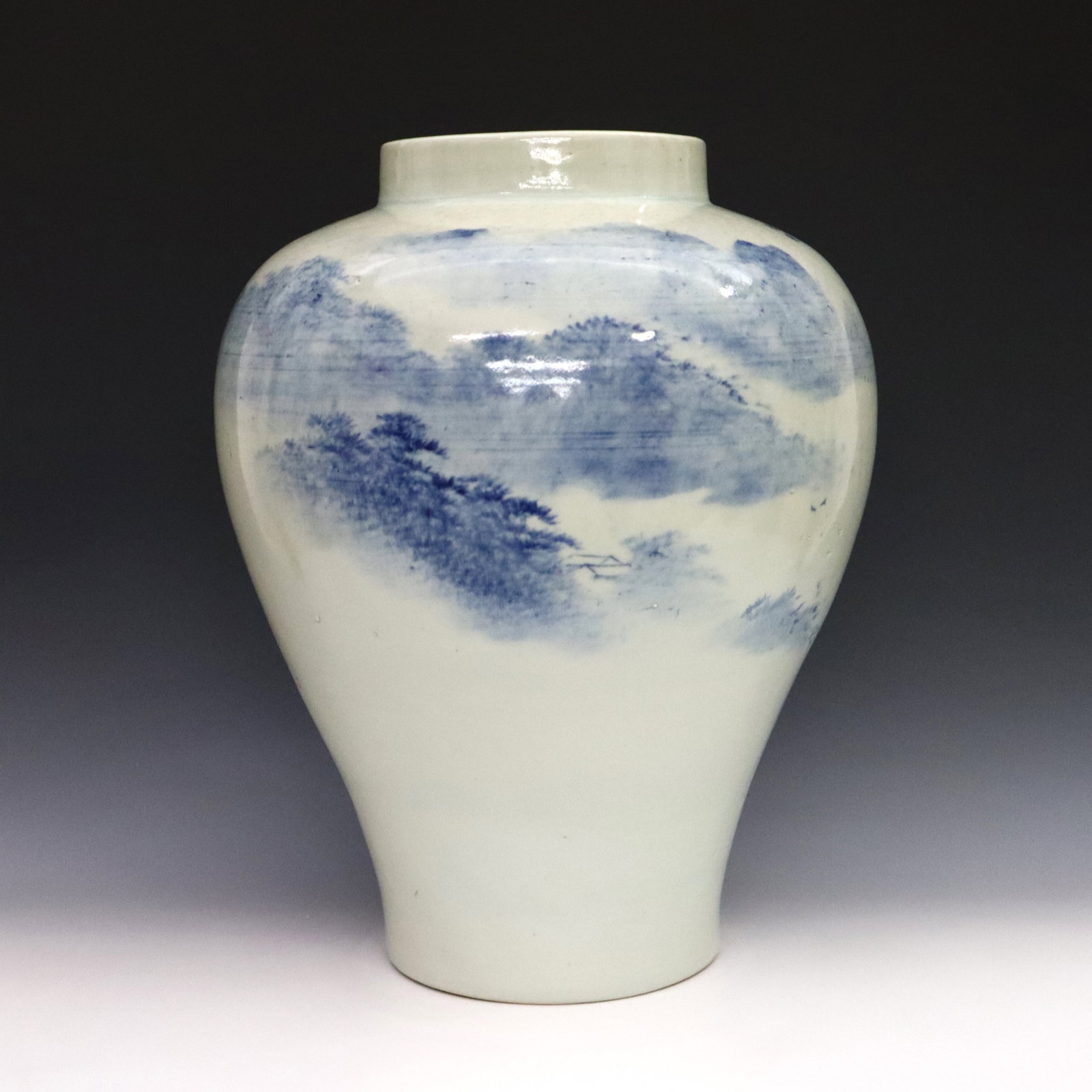 Korean Blue & White Porcelain Vase: A Korean Blue and White porcelain vase. Baluster form with hand-painted landscape decoration with calligraphy at the shoulder. Marked at the underside. There is production flaw evident at base, light 