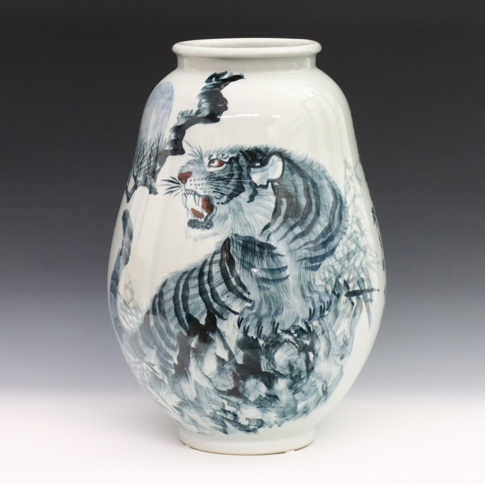 Korean Blue & White Porcelain Vase: A Korean Blue and White porcelain vase. Tapered form with rolled rim and hand-painted decoration depicting a tiger amongst foliage. Calligraphy at one side of the body, three character mark at the und