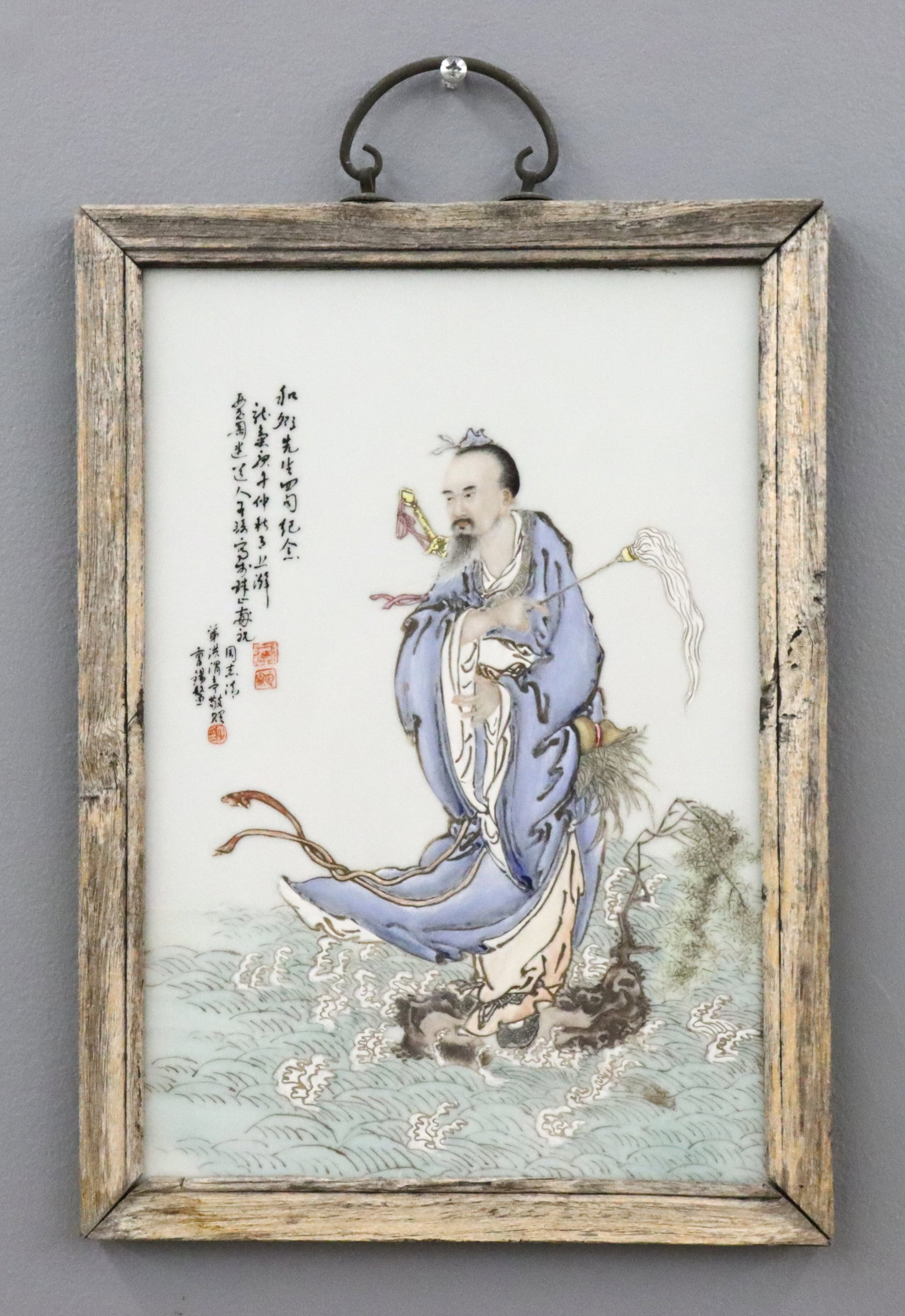 Chinese Porcelain Plaque: An early 20th century Chinese porcelain plaque. Polychrome enameled decoration depicting the figure of Lu Dongbin, one of the Eight Immortals, shown with a sword on his back and a fly brush in his han