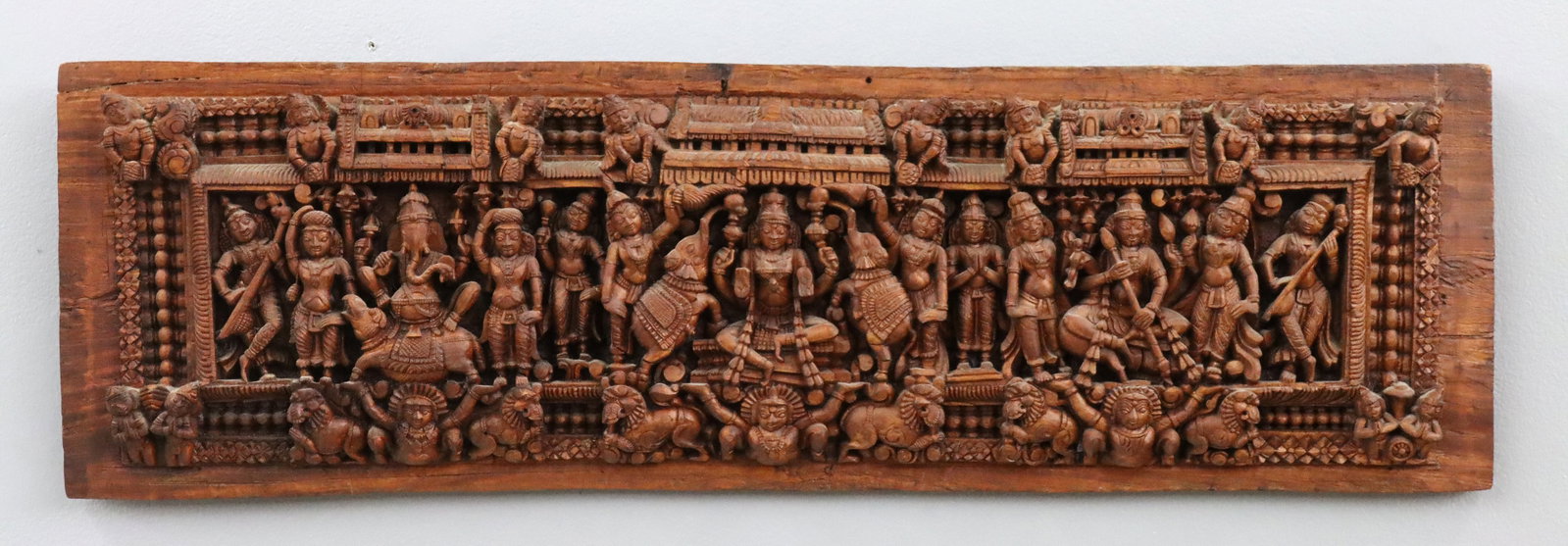 Indian Carved Panel: An Indian carved temple panel. Carved hardwood Hindu temple panel/frieze in high relief featuring three Hindu deities, including Lord Ganesha, Goddess Gajalakshmi, and Saraswati. Minor nicks, light we