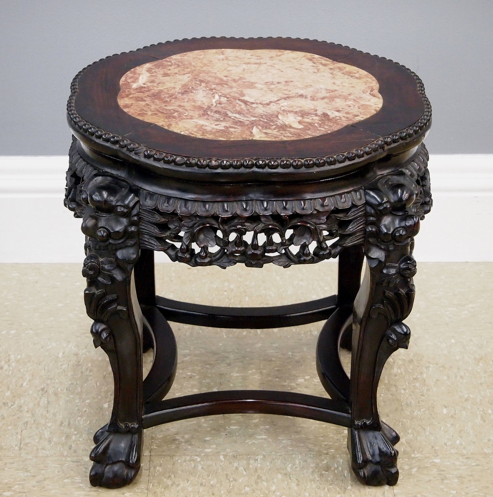Chinese Low Side Table: A turn of the century Chinese low side table. Rosewood construction with carved foliate design features a shaped top with marble insert over a carved skirt and four short cabriole legs with mask knees