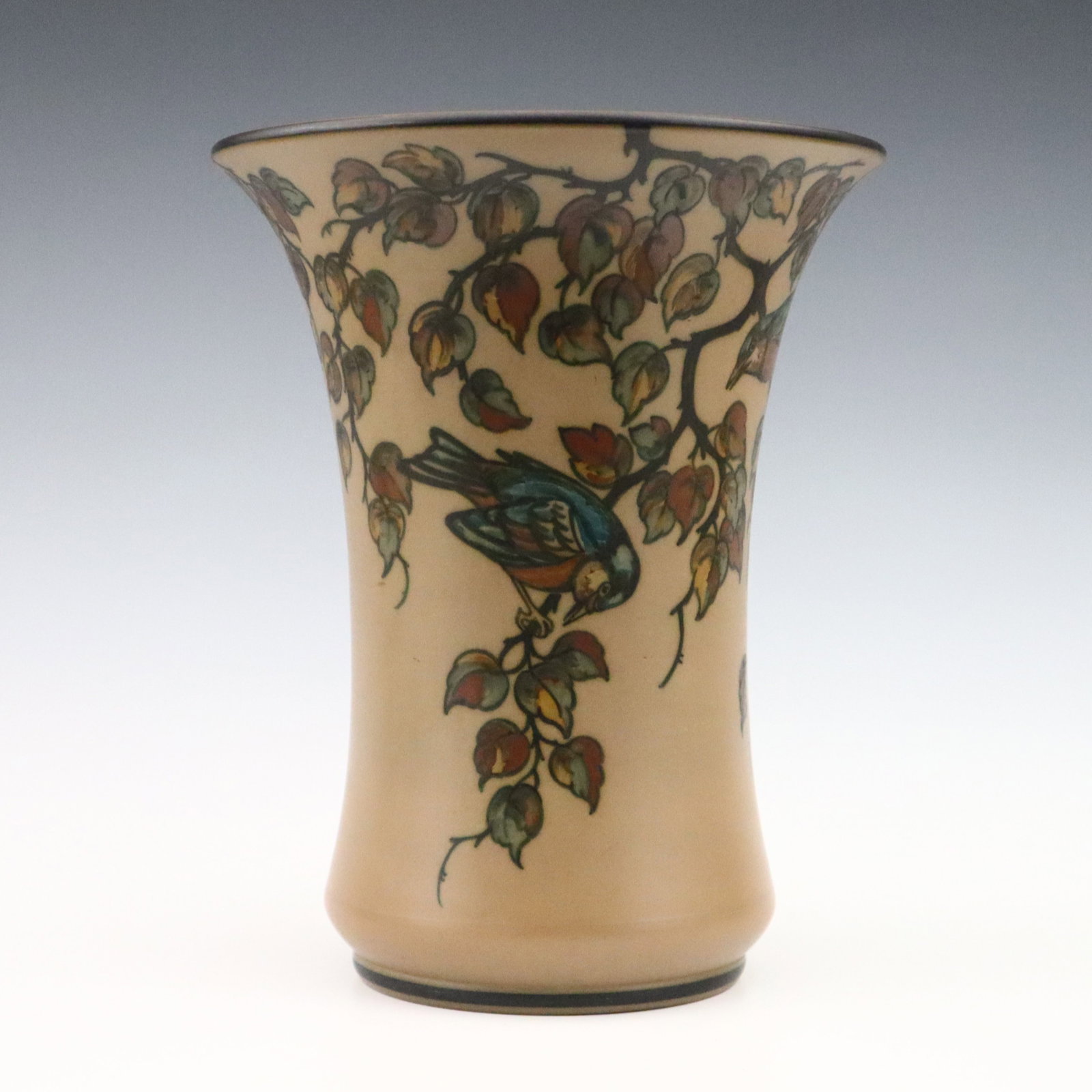 L. Hjorth Art Pottery Vase: An early 20th century L. Hjorth Art Pottery vase. Flared form with multi-color songbird and fruit tree decoration on a matte Brown ground. Impressed "L. Hjorth" and "Denmark" marks. Slight wear. 10