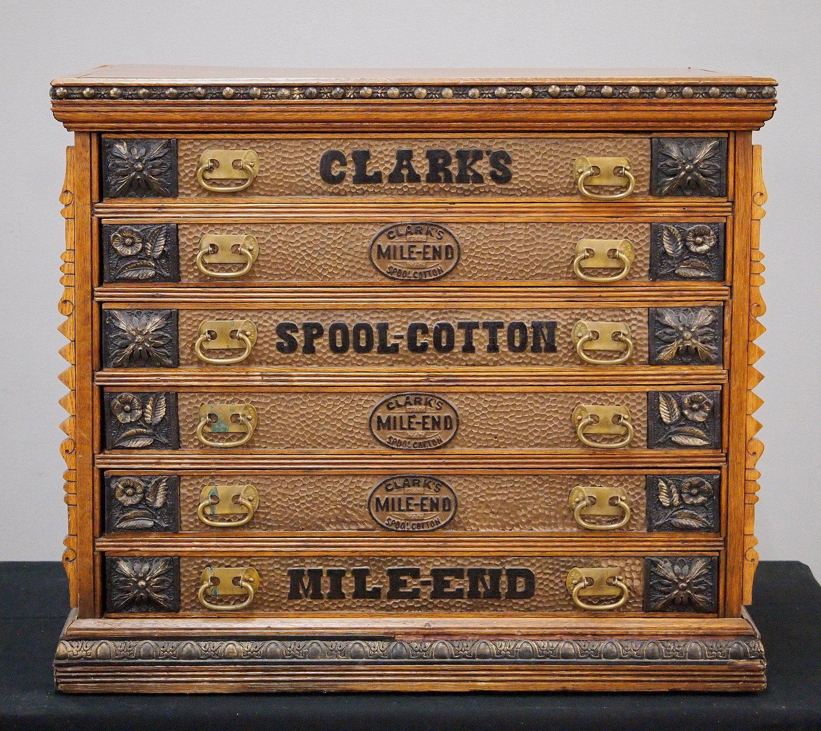 Clark's Spool Cabinet: A turn of the century Clark's Spool Cabinet. Oak construction features six labeled dovetailed drawers with brass handles. Older refinish with some wear, some separation, nicks/losses. 25 1/2 x 17 3/4 