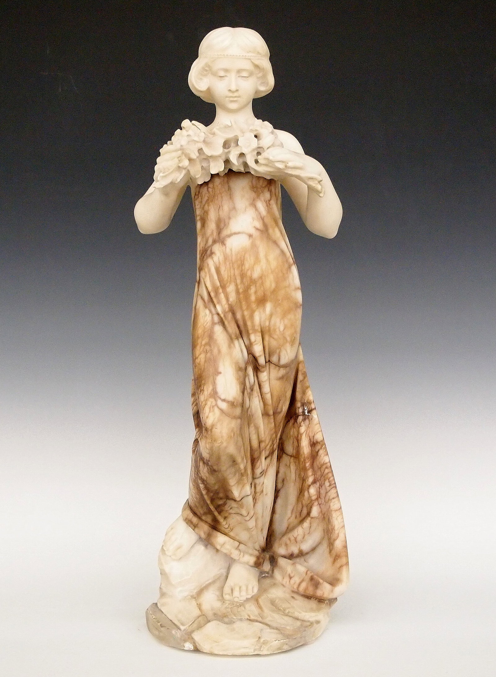 Italian Alabaster & Marble Sculpture: An Italian Art Nouveau Alabaster and Marble sculpture. Carved figure of a woman shown holding a floral garland. Unsigned. 13 5/8" high. Wear overall with some fill evident. ESTIMATE $400-600
