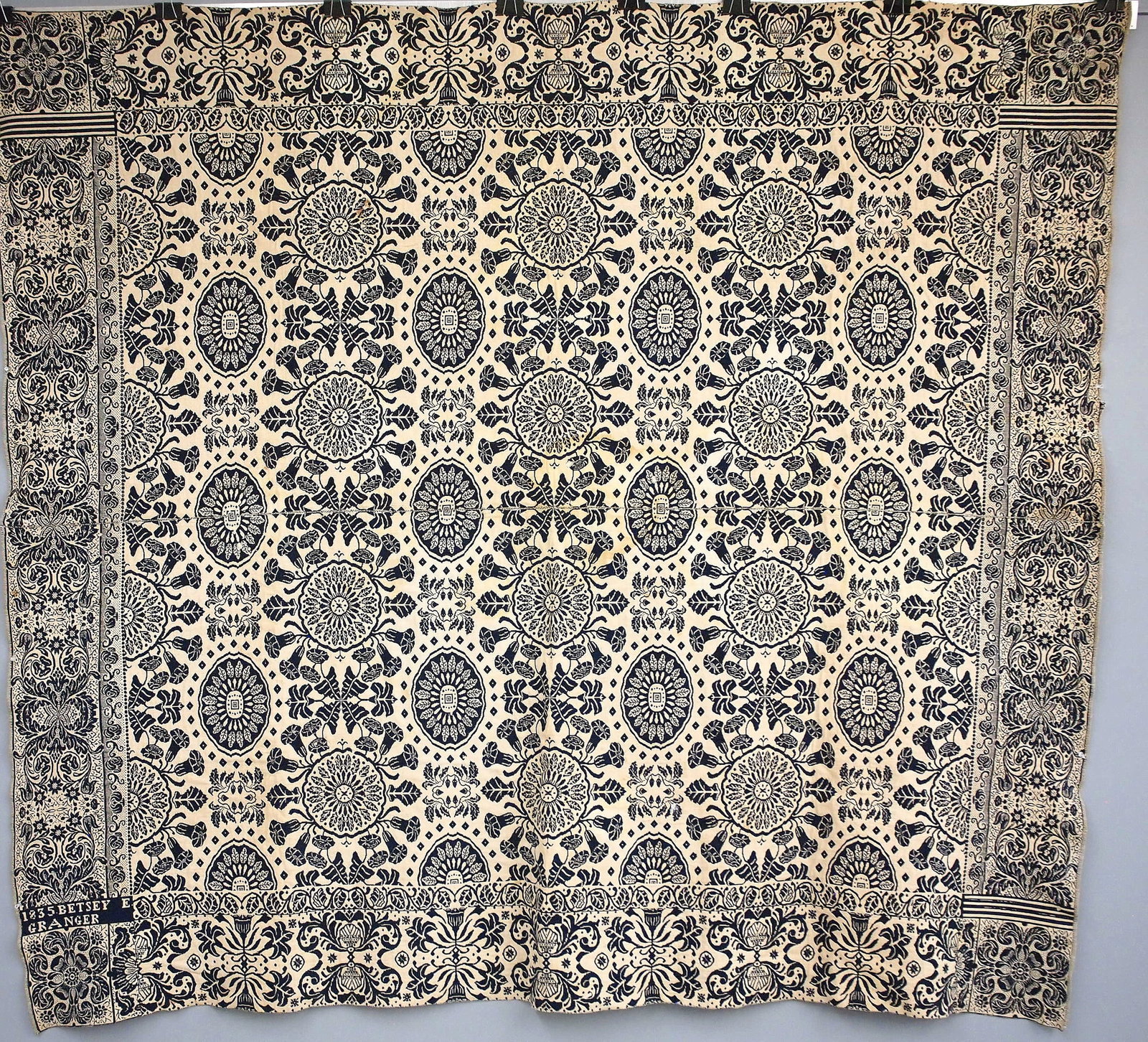 American Jacquard Coverlet: A 19th century American Jacquard coverlet. Two piece construction with floral design in Navy Blue and White consisting of a repetitive rose pattern, contained within alternating borders of either bird