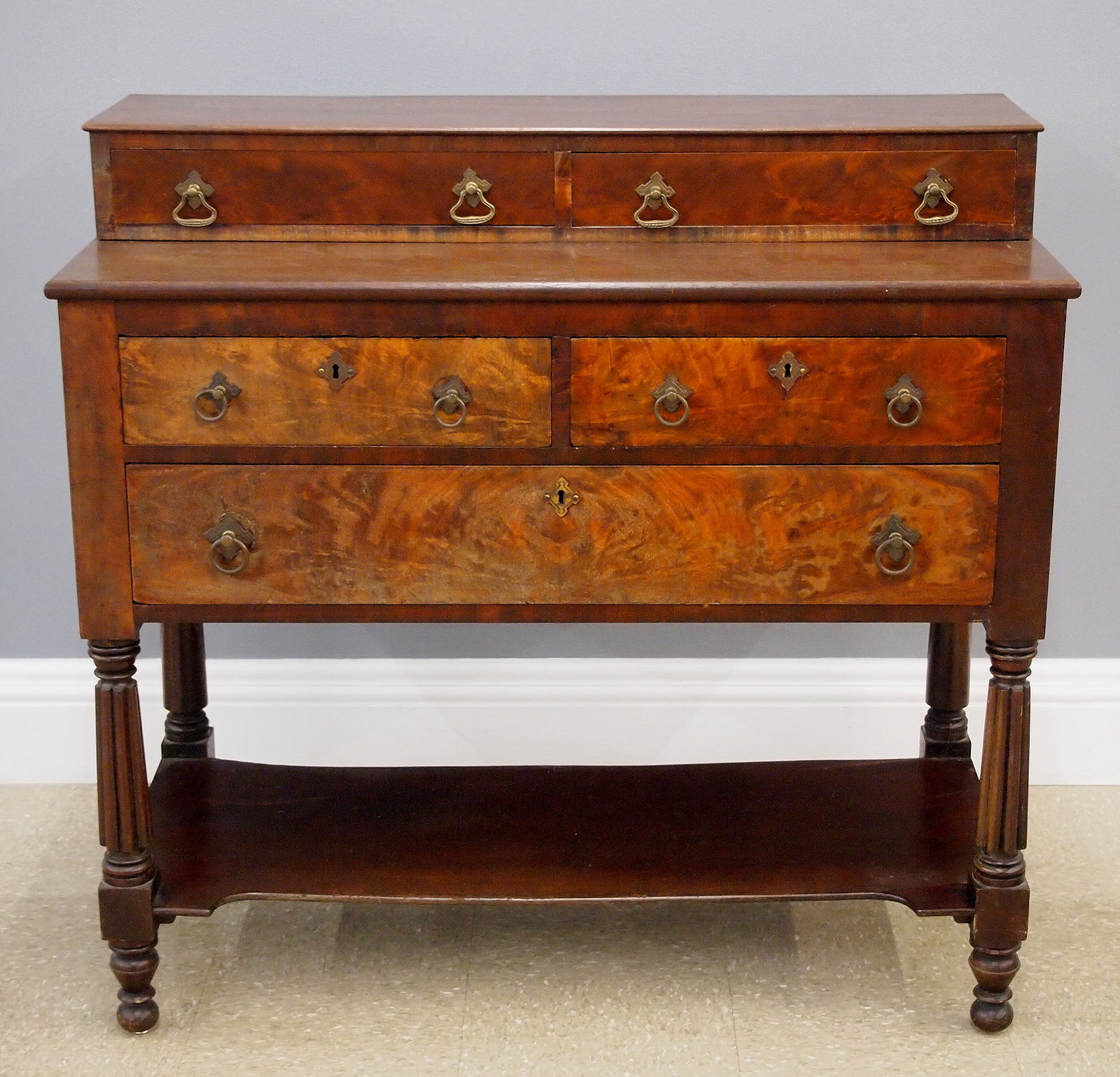 American Sheraton Server: A 19th century American Sheraton Period server. Mahogany construction with Crotch Mahogany drawer fronts features two drawers at the upper section and two smaller drawers above one larger drawer at th