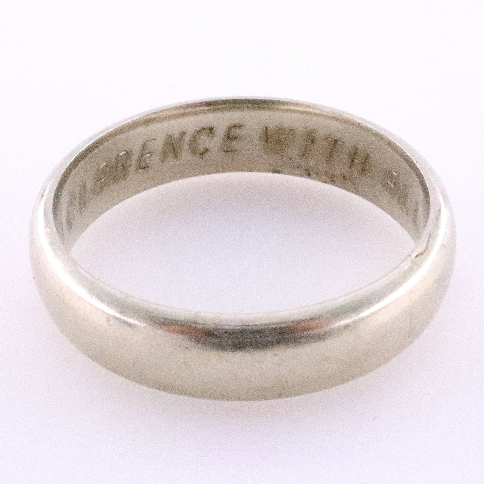 14k Gold Orange Blossom Wedding Band: A 14k White Gold Traub Orange Blossom gentleman's wedding band. Simple 5.5 mm domed band. Marked "14k" and "Orange Blossom". 7.0 grams total. Some surface wear, inscribed along the interior of the ban