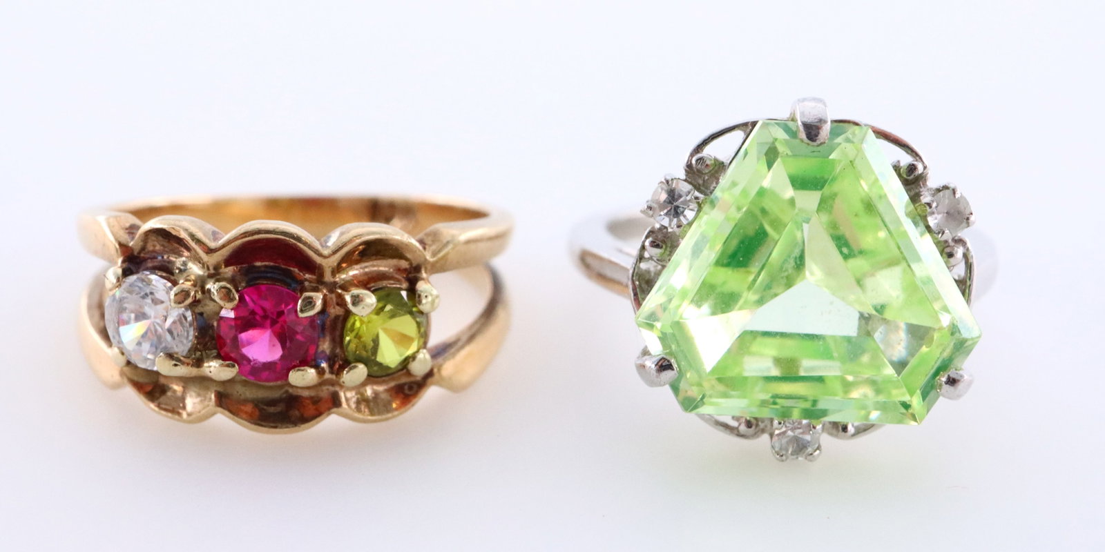 2 10k Gold rings: Two 10k Gold ring with semi-precious stones. Features one with triangular cut Green Spinel or Tourmaline surrounded by gemstone accents on a simple band, the other with three birthstones on a scrolled