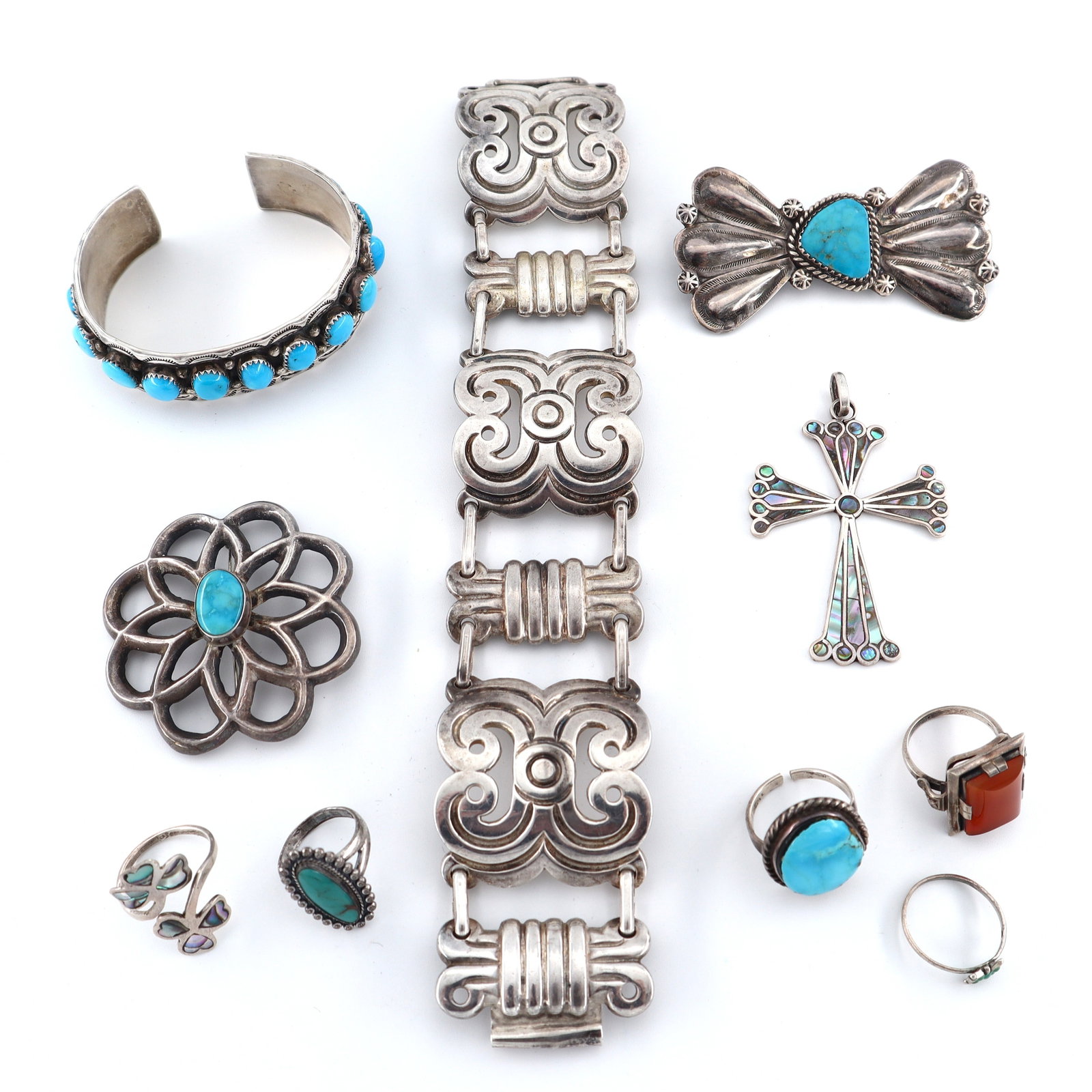 10 Sterling Accessories: Ten vintage Sterling Silver accessories. Includes a Casa Prieto segmented bracelet, a Native American cuff with Turquoise, two Southwest brooches with Turquoise, a cross pendant with inlaid Abalone, a