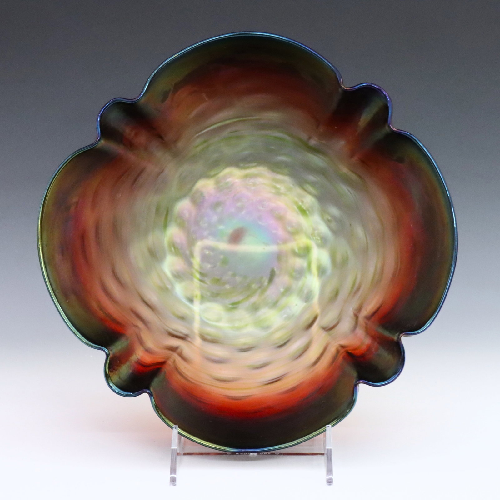 Rindskopf Art Glass Bowl: A turn of the century Rindskopf Art Glass bowl. Crimped Rubina Verde glass body with Iridescent finish. Unmarked. Minor surface wear and fleabites. 10 x 4" high overall. ESTIMATE $100-200