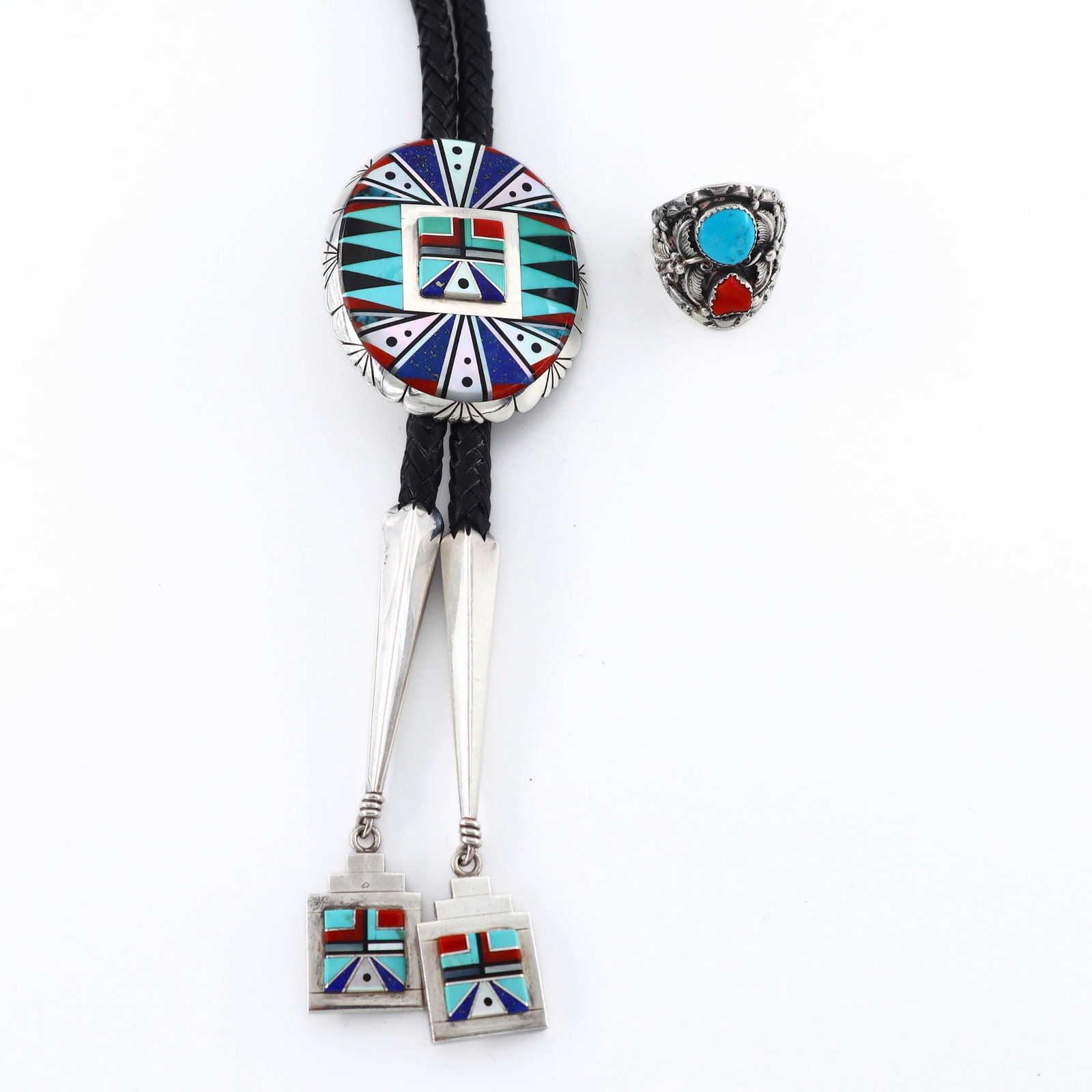 Navajo Sterling Bolo Tie & Ring: A vintage Navajo Sterling Silver bolo tie and ring. Includes a bolo tie by Chester Benally featuring an oval geometric design inlaid with various stones and shell, on a braided leather tie with Sterli