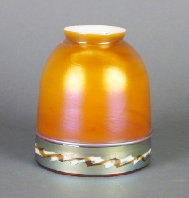 Steuben Intarsia shade: A Steuben Intarsia Art Glass shade. Bell form with Brown/Gold Aurene cased glass with a zigzag lower band. Unsigned, slight wear, slight fitter roughness. 4 3/4" high. ESTIMATE $400-600