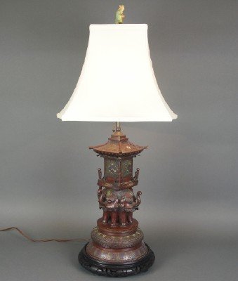 Chinese Champleve lamp: A turn of the century Chinese Bronze table lamp with extensive Champleve enamel detail. Pagoda form with Elephant supports on a carved wooden base. Minor wear, one replaced socket, finial damaged. 34