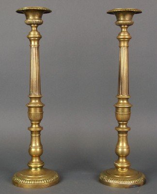 Pr Brass candlesticks: A pair of late 19th century Brass Altar candlesticks. Tall stems with fluted detail and circular beaded bases. Some wear and minor denting. Each 18" high. ESTIMATE $100-150