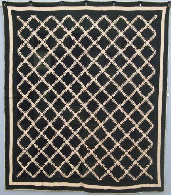 Patchwork Quilt: A turn of the century American Patchwork quilt. "Log Cabin, Flying Geese" pattern in Black and Peach, with a needlework edge detail. Some fading, wear and minor damage. 66 x 77" overall. ESTIMATE $200