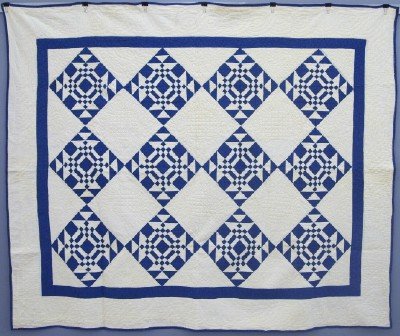 Patchwork Quilt: A turn of the century American Patchwork quilt. Unknown "5 Patch" pattern in Blue and White. Some wear, minor damage and minor staining. 72 x 87" overall. ESTIMATE $200-400