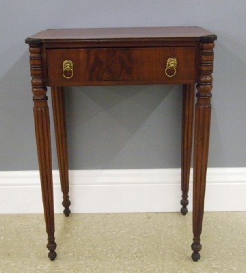 Sheraton side table: An early 19th century American Sheraton Period side table. Mahogany with shaped top and turned "Cookie" corners, above a single dovetailed drawer with Lion's Mask pulls and turned reeded legs. Older r