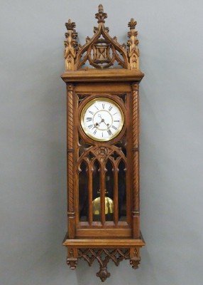 Gothic wall clock: A late 19th century German Gothic Revival Period wall clock by Kinzle, Schwenningen. Walnut case with extensive hand carved detail including Gothic Arches and Spires. 8-day spring driven time and stri