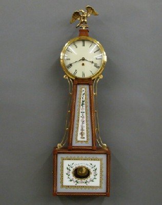 Federal style Banjo clock: A reproduction of an American Federal style banjo clock. 8 day time only spring driven movement. Mahogany case with Eglomise panels, surmounted by a gilded eagle. Marked "S. Willard's Patent". Minor w