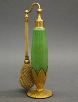 DeVilbiss Perfume Bottle: An Art Deco Era DeVilbiss Perfume Bottle. Richly decorated Bohemian opaque green glass with embossed fired gold at the base and foot with gilt metal mounts and cloth atomizer. Marked at the underside 