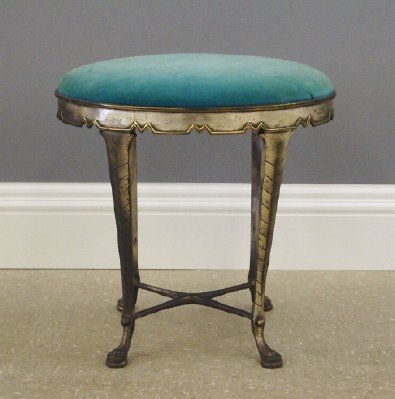 Art Deco Stool: A 1930's Art Deco Iron Stool. Oval skirt with geometric edge and brass detail on Four simple cabriole legs with a stretcher base. Original chrome finish shows some wear. 18" long x 14" wide x 18" high