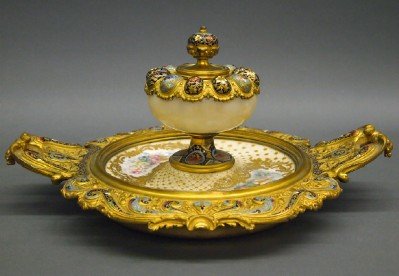French Ink stand: A turn of the century French Enameled Bronze Inkstand. Cast Gilded Bronze two handled base with extensive multi color floral Champleve enamel decoration contains a porcelain bowl with hand painted Put
