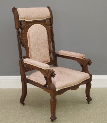 American Aesthetic Arm Chair: A Late 19th Century American Aesthetic Carved Cherry Arm Chair. Having a shaped back with carved winged Mythological figures, carved lion's paw hand rails with griffon form hand holds; the head rest,